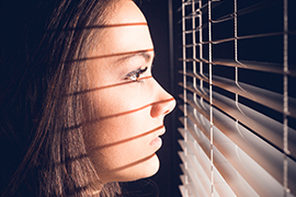 Frau im Fensterlicht mit Jalousie